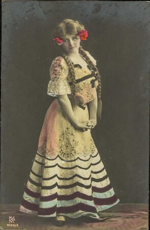 [Frau in traditionellem Kleid mit Blumenschmuck]