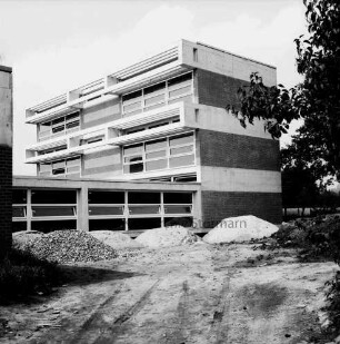 Schulen: Grund- und Hauptschule mit Realschulzug Trittau [später Hahnheide-Schule]: Erweiterungsbau mit Zwischentrakt: Außenansicht: davor Sand- und Kieshaufen