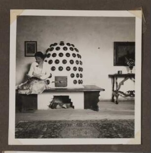 Innenaufnahme von Schloss Prielau in Zell am See 1934 mit Frau am Kaminofen