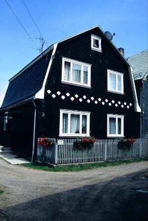 Giebelseite eines Schieferhauses mit Mansarddach