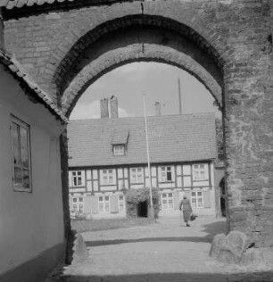 Stralsund. Blick durch einen Tordurchgang auf eine Straße mit Fachwerkhäusern