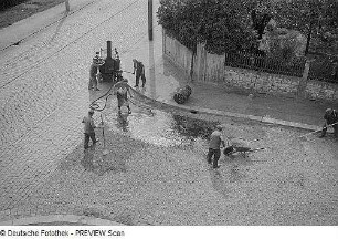 Dresden-Leutewitz. Auf der Scheibe, Straßenbauarbeiten, Herstellen einer Einstreudecke (Splitt) auf bituminösen Bindemittel, aufgebracht mit Bitumenspritzmaschine
