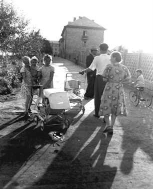 Alltagsszene mit Passanten und Kinderwägen