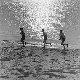 Jugendliche laufen am Strand entlang