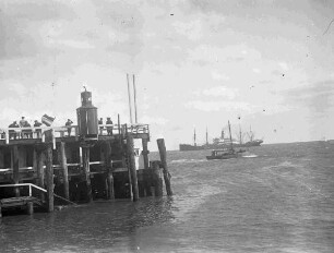 Schiffsanleger, vermutlich Cuxhaven mit Dampfschiff im Hintergrund
