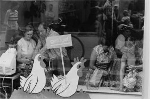 Kunden in einem Lebensmittelgeschäft von außen durch die Schaufensterscheibe fotografiert