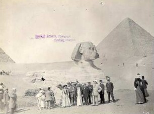 Gizeh (Ägypten): Vor der Sphinx. Im Hintergrund Cheops-Pyramide, Touristen und Fremdenführer vor der Sphinx von Gizeh