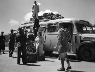 Reisefotos. Postauto mit Reisenden beim Ausladen von Gepäckstücken