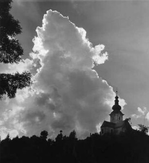 Wolkenbilder. Kärnten. Kumuluswolke über einer Kirche (vielleicht St. Michael in Kirchbach)