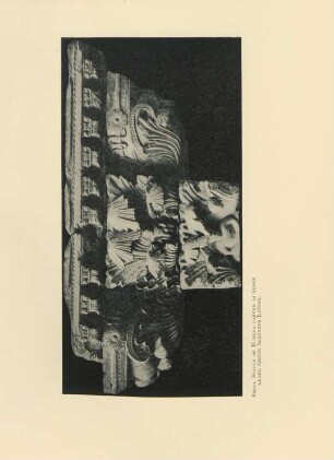 Small statue of Buddha carved in stone among greek acanthus leaves