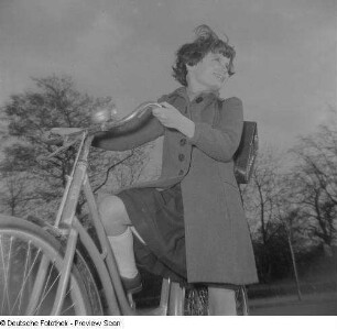 Ein Mädchen mit Schulranzen auf einem Fahrrad