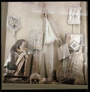 Mumie und ethnologisches Kunsthandwerk in einem Schaukasten
