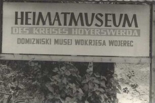 ZweisprachigeTafel vor dem Heimatmuseum des Kreises Hoyerswerda : Dwurěčna tafla před zachodom do Domizniskeho muzeja Wojerowskeho wokrjesa