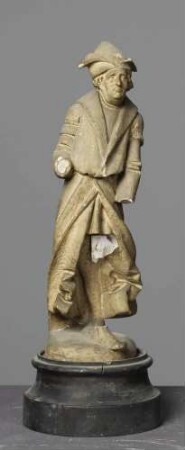 Mann mit spitzer Mütze und zurückwehendem Mantel