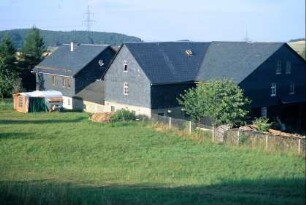 Grünland, Zäune, dahinter Gebäude