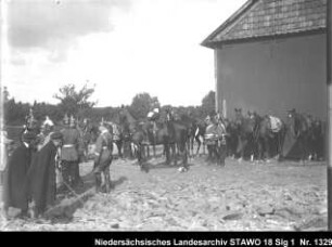 Manöver des 10. Armee-Korps Enthält: Platte 3, rastende und sich unterhaltende Soldaten mit Pferden vor der Wand eines Gebäudes