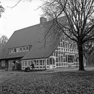 Kreiskinderheim Grande: Außenansicht nach Aufbau und Renovierung wegen Brand: vor dem Haus Gartenarbeiten mit Walze