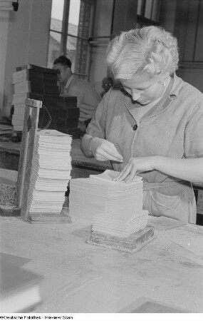 Buchbinderin beim Einbinden eines Buches