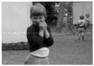 Mädchen, dahinter Kinder die spielen (Altersgruppe bis 14)