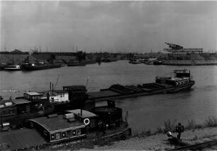 Duisburg-Ruhrort. Ansicht des Aussenhafens. Mit Schüttgut beladene Schleppkähne liegen am Kai bzw. im Hafenbecken