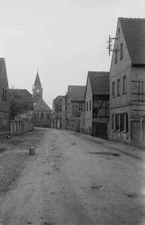 Dorfstraße : Blick auf eine Dorfstraße. Im Hintergrund eine Kirche