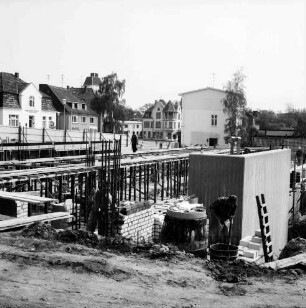 Käselau: Kaufhaus: Bahnhofstraße: in Bau: Kellergeschoss: Mauern, Stahlarmierung, Leiter, Bretter, Arbeiter: hinten Bauzaun, Häuser