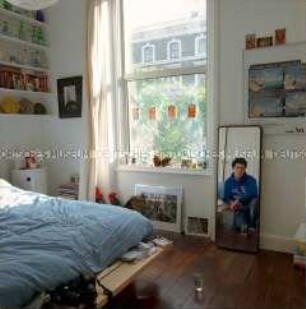 Jugendzimmer mit Spiegelbild eines sitzenden Jugendlichen (Altersgruppe 18-21)