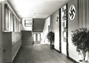 Nassau/Erzgebirge, Schule, Inneres, Flur, Wandschmuck, von Hakenkreuzen und Kübelpflanzen flankierte nationalsozialistische Propaganda "Du bist nichts - Dein Volk ist alles"
