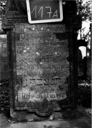 Grabstein 117 (Index: 100111242) Material: Sandstein Zustand: leicht verwittert Maße HxBxT: 146x60x25 cm Beschreibung: Stele, Sockel, Rundbogenaufsatz über ausgezogenem Steleteil, rechteckig erhöht Symbolik: Rosen: Grabstein 117A
