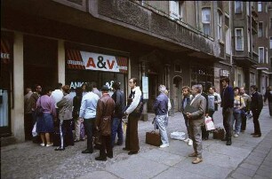 Berlin-Mitte, Weinbergsweg. Warteschlange vor einem "A & V" Laden für An- und Verkauf gebrauchter Industriewaren