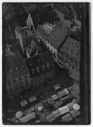 Blick vom Kirchturm (?) auf den Marktplatz einer Stadt mit Marktständen