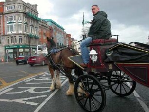 Fiaker-Kutscher wartet an einer Kreuzung im Zentrum von Dublin auf freie Fahrt