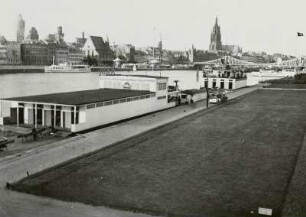 Frankfurt, Blick über das Mainufer : Frankfurt. Blick vom linken Mainufer (mit Bootshaus und -verleih) nach Südwesten gegen das Stadtzentrum mit Katholischer Kirche St. Leonhard. Mainkain und Dom