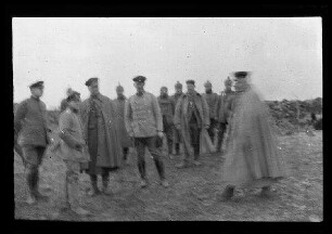 Nicht identifizierbare Gegend in Nordfrankreich oder Belgien: Offiziere mit Schirmmütze, einer davon mit Umhang, im Hintergrund Offiziere mit Pickelhaube