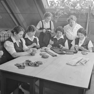 Werkfrauen beim Flicken von Kleidungsstücken