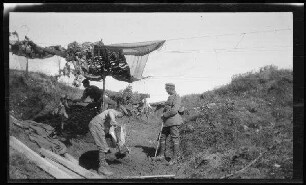 Épehy (Dep. Somme, Frankreich): Offizier neben hemdsärmeligen Soldaten mit Schaufeln unterhalb einer an Schnüren befestigten Tarnung ("Stellung, Hohlweg bei der Priel Ferme, Vizefeldwebel Boyle")