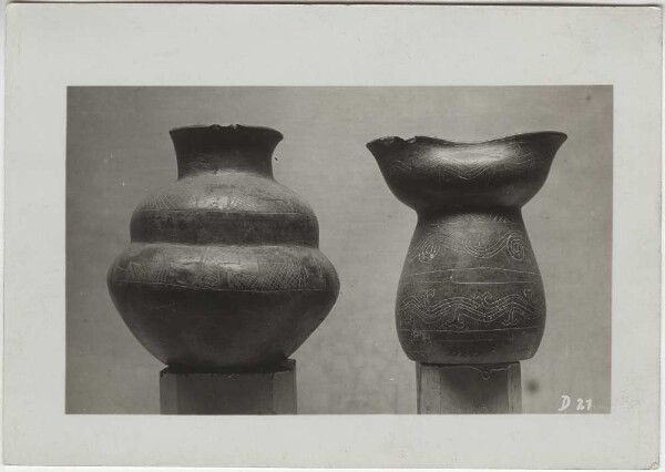 Two clay vessels made of smooth, black clay with incised markings. Height 11-14cm. Guillermo de Heredia Collection.