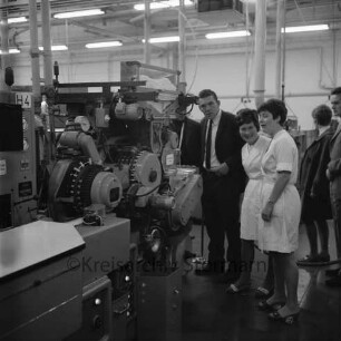 British American Tobacco Company GmbH B.A.T.: Beimoorweg: Zigarettenfabrik: Tag der offenen Tür: Innenaufnahme: Angestellte und Besucher bei Maschine zur vollautomatischen Zigarettenherstellung und Befilterung