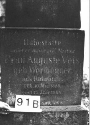 Grabstein 91 (Index: 99898863) Material: Sandstein Zustand: leicht verwittert, Sockel stark verwittert Maße HxBxT: 136x48x24 cm Beschreibung: aufgesockelte Stele mit eingezogenem Rundbogenabschluss, unterer Sockel felsartig gearbeitet: Grabstein 91B