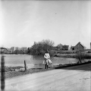 Dorfteich nach Auffüllung mit Wasser: am Ufer Mädchen: vorn Dorfstraße: im Hintergrund Wohn- und Bauernhäuser