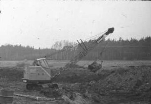 Universalbagger KM 251 in Schürfkübelausrüstung beim Grabenneubau
