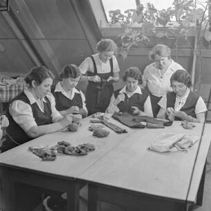 Werkfrauen beim Flicken von Kleidungsstücken