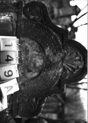 Grabstein 149 (Index: 99751970) Material: Sandstein Zustand: verwittert mit Textverlust, abgeblättert Maße HxBxT: 126x74x10 cm Beschreibung: Stele, in Voluten auslaufend. Rundbogenaufsatz, rechteck. Schriftfeld eingetieft Symbolik: Krone, Voluten, Ranken: Grabstein 149A