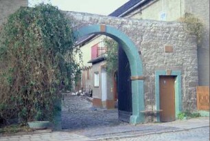 steinerner Rundbogen als Zufahrt zu einem Bauernhof