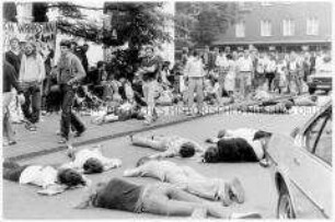Jugendliche liegen während eines Friedensmarsches auf der Straße (Altersgruppe 18-21)