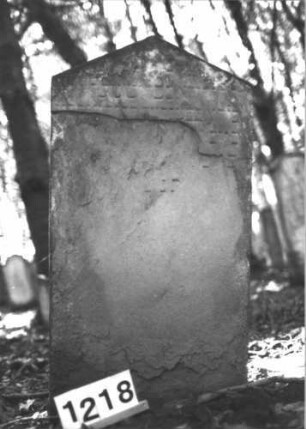 Grabstein 1218 (Index: 99899993) Material: Sandstein Zustand: fast völlig verwittert Maße HxBxT: 102x57x10 cm Beschreibung: Stele mit Dreiecksabschluss: Grabstein 1218