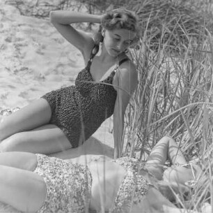 Elisabeth Gremmler (rechts) und eine Freundin liegen in Badebekleidung am Strand