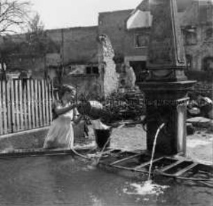 Arbeitsmaid des Reichsarbeitsdienstes am Brunnen im zerstörten Haltingen