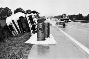 Bundesautobahn 1: bei Stapelfeld, Richtung Lübeck: Verkehrsunfall: umgestürzter Kühl-Lkw mit Anhänger in Böschung: vorn und hinten Dieseltanks: im Hintergrund Absperrung, Pkws und Lkws: 21. September 1999
