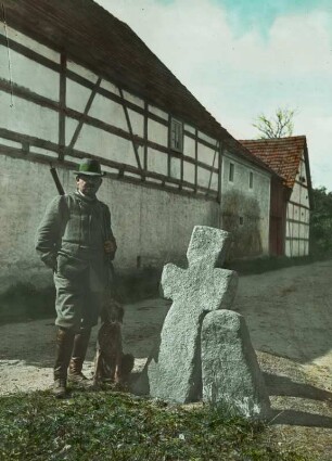 Steinkreuz, Sühnestein und Jäger mit Hund : Steinitz, Steinkreuz und Sühnestein mit Ritzzeichnung eines Schwertes am Dorfplatz, daneben ein Jäger mit seinem Hund